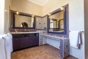 a bathroom with two sinks and two mirrors at Charmante Villa Riad Dharma in Essaouira