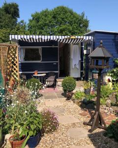 een tuin met een camper en een prieel bij Down The Garden Path Vintage Caravan B&B , Hennock in Newton Abbot