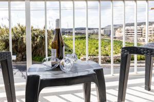 Una botella de vino en una mesa con dos sillas en Seaside Flat with Scenic Country Views en Mellieħa