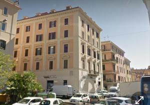 ein großes Gebäude mit Autos auf einem Parkplatz in der Unterkunft Appartamenti Doria in Civitavecchia
