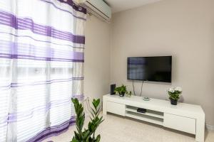 sala de estar con ventana grande y TV en Seaside Flat with Scenic Country Views en Mellieħa