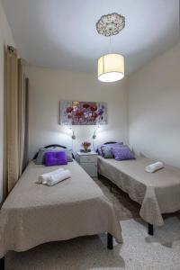 a bedroom with two beds and a chandelier at Seaside Flat with Scenic Country Views in Mellieħa