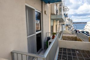 un balcón de un edificio con vistas al agua en Seaside Flat with Scenic Country Views en Mellieħa