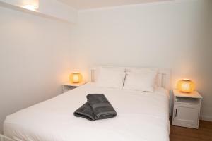 a bedroom with a white bed with two lamps at 2 Bedroom Apartment House - Sol do Murtal in Parede