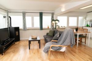 uma sala de estar com um sofá e uma televisão em 2 Bedroom Apartment House - Sol do Murtal em Parede