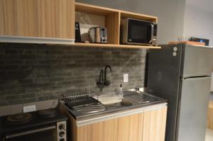 a kitchen with a sink and a refrigerator at Temporarios Santiago in Santiago del Estero