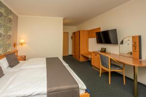 ein Hotelzimmer mit einem Bett und einem Schreibtisch in der Unterkunft Waldhotel Kurfürst in Kaisersesch