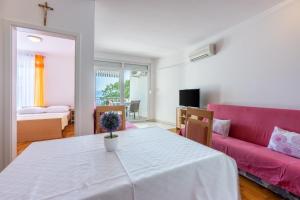 uma sala de estar com uma mesa e um sofá rosa em Pasalic Novi em Novi Vinodolski