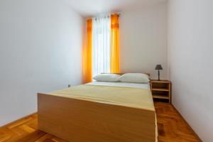um quarto com uma cama com uma moldura de madeira e uma janela em Pasalic Novi em Novi Vinodolski