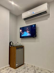 uma televisão de ecrã plano na parede de um quarto em Life Pyramids Inn no Cairo