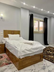 ein großes Bett in einem Schlafzimmer mit Fenster in der Unterkunft Life Pyramids Inn in Kairo
