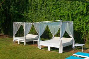 two beds in a yard next to a wall at Hotel Vibra Marco Polo I - Adults only in San Antonio