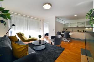 a living room with a couch and chairs and a kitchen at Lavir Apartment with parking in Zagreb