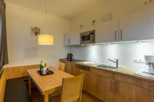 una pequeña cocina con mesa de madera y fregadero en 2 Raum Wohnung Superior, en Schulenberg im Oberharz