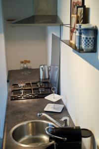 a kitchen counter with a sink and a stove at B&B de Fruithof in Heteren