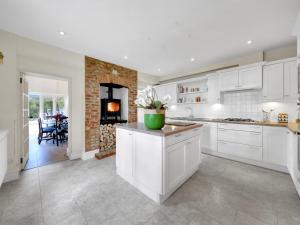 a kitchen with white cabinets and a fireplace at Pass the Keys Sunset House18th cent cottage stunning garden in Chipping Norton