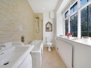 a bathroom with a sink and a toilet andwindows at Pass the Keys Sunset House18th cent cottage stunning garden in Chipping Norton