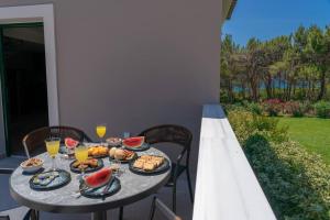 een tafel met eten en drinken op een patio bij Seashell Luxury Residence - Apartment 2 in Lixouri