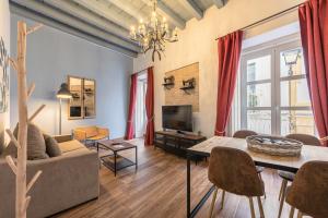 uma sala de estar com um sofá e uma mesa em Green-Apartments Mansión Blue Catedral em Sevilha