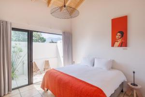 a bedroom with a white bed and a large window at Good Hotel Antigua in Antigua Guatemala