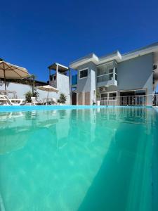 a large swimming pool in front of a house at Hotel Pousada Mar Azul in Itapoa