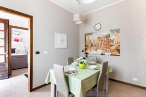uma sala de jantar com uma mesa e um relógio na parede em “Casa Moderna con parcheggio privato” em Imola