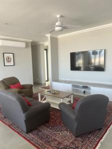 a living room with two chairs and a flat screen tv at Seadrive in Walvis Bay