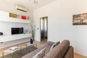 uma sala de estar com um sofá e uma televisão em “Casa Moderna con parcheggio privato” em Imola