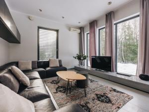 a living room with a couch and a tv at Villa Saskia in Otepää