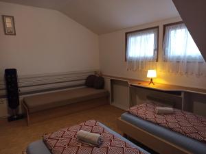 1 Schlafzimmer mit 2 Betten, einem Sofa und einem Fenster in der Unterkunft Penzion Pasohlávky in Pasohlávky