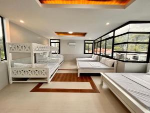 um quarto com duas camas, um sofá e janelas em 8 Flags Private House and Hot Spring Pool em Los Baños
