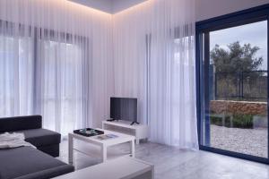 a living room with a couch and a tv at Augoustos ECO luxury apartments in Aghia Marina