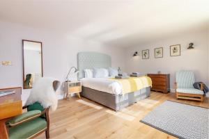 1 dormitorio con cama, escritorio y silla en Burnside - gorgeous romantic cottage for 2 en Monzie