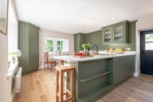 a kitchen with green cabinets and a white counter top at Burnside - gorgeous romantic cottage for 2 in Monzie