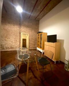 sala de estar con mesa de cristal y sillas en Casa amplia, luminosa y alegre en Buenos Aires