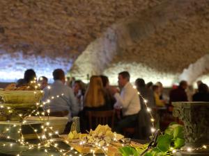 eine Gruppe von Menschen, die an einem Tisch mit Lichtern sitzen in der Unterkunft Château du Souzy in Quincié-en-Beaujolais