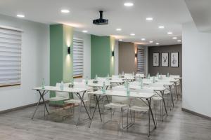einen Konferenzraum mit weißen Tischen und Stühlen in der Unterkunft Hotel Elche Centro , affiliated by Melia in Elche