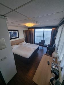 een hotelkamer met een bed en een tafel en stoelen bij Eemshotel in Delfzijl