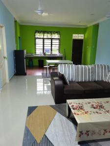 a living room with a couch and a table at Makmur Homestay Marang in Marang +14 photos