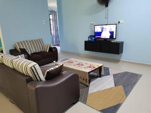 a living room with two couches and a tv at Makmur Homestay Marang in Marang