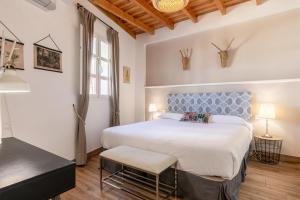 um quarto com uma cama grande e uma cabeceira azul em Green-Apartments Mansión Blue Catedral em Sevilha