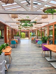 un restaurant avec des tables, des chaises et des fenêtres dans l'établissement Hotel Perlyna ARS, à Stry