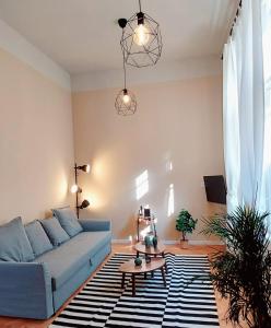 een woonkamer met een blauwe bank en een tafel bij A+ Budapest Downtown Apartments Akácfa in Boedapest