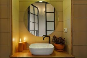 a bathroom with a sink and a mirror with two candles at Luxury House in Tbilisi City