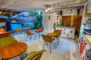 a restaurant with tables and chairs in a room at Naturale Guest House in Nusa Lembongan