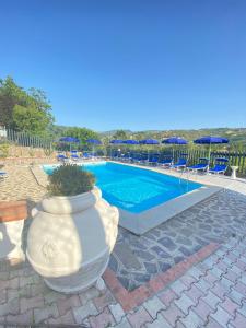un grande vaso bianco seduto accanto alla piscina di Serra Marina Rooms and Apartments a Santa Maria di Castellabate