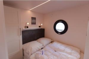 a small bedroom with a bed and a window at Hausboot Fjord Dory mit Biosauna in Schleswig in Schleswig