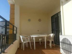 een witte tafel en stoelen op een balkon bij Enjoy Life Chipiona in Chipiona