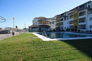 un edificio con piscina frente a un edificio en PlayaWifi2 dorm2 baños6 persParking cerrado, en Chipiona