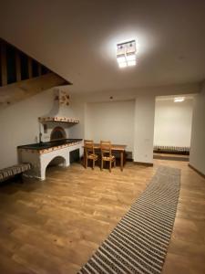 a living room with a fireplace and a table and chairs at Kanada in Berezovka